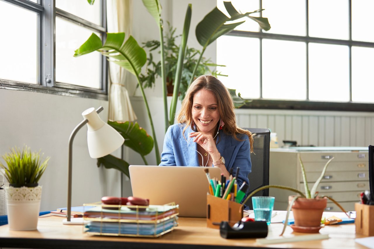 Woman sitting in front of laptop and smiling