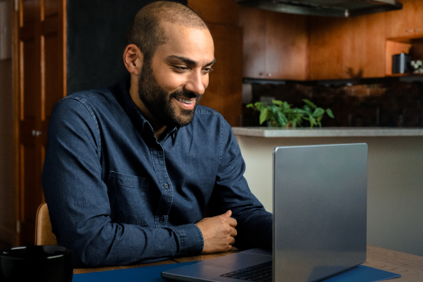 Man smiling into laptop